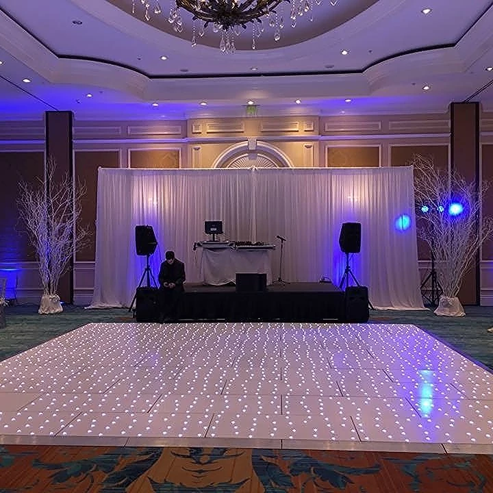 Ballroom wedding reception with an LED dance floor and DJ booth set up by Nation Wide Sound DJ’s
