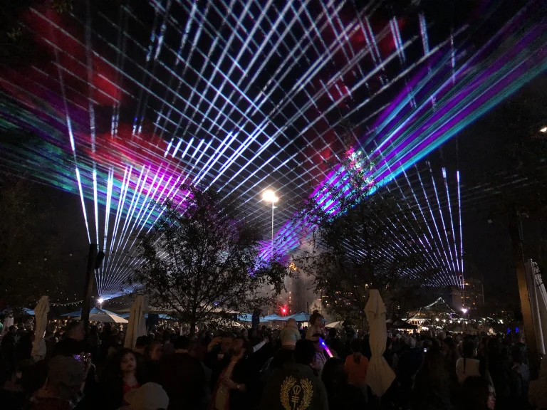 Laser light show over an outdoor evening crowd
