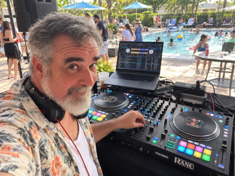 DJ 2RO with headphones around his neck at a Rane Performer during an afternoon pool party