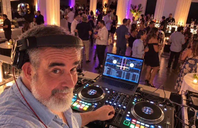 DJ 2RO at a Rane Performer controller overlooking a crowded ballroom event with warm uplighting