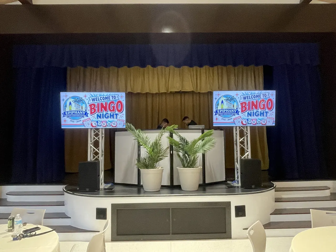 Stage set for Epiphany 75th Anniversary Bingo Night with DJ booth, truss-mounted screens and speakers