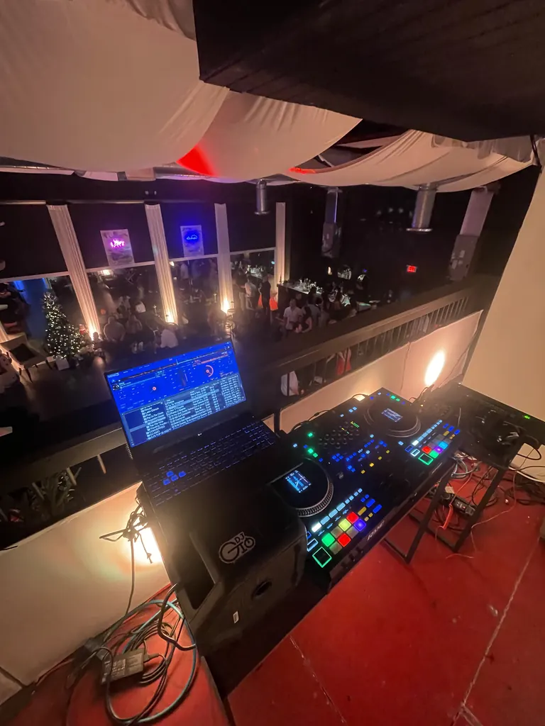 Nightclub DJ booth with Rane controller and laptop above the dance floor